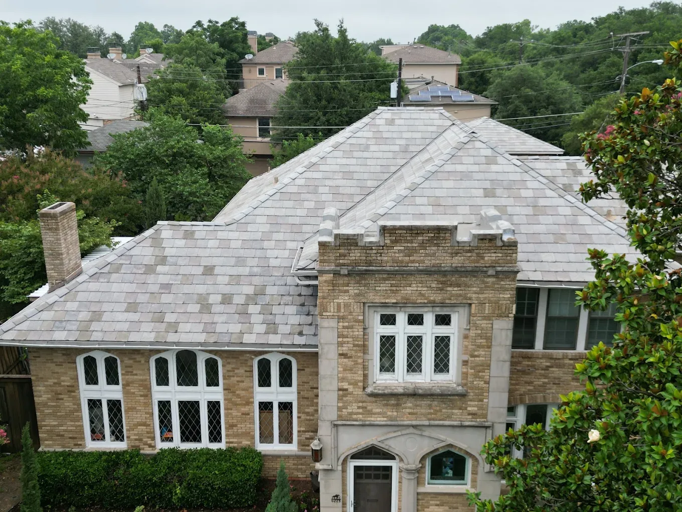 Multi-tone synthetic slate roof on a Tudor-style brick home in Dallas–Fort Worth